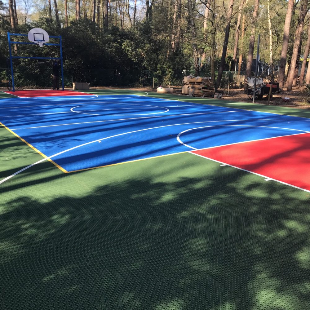 Rubber sports court with vibrant blue, red, and green colours of FlexCourt