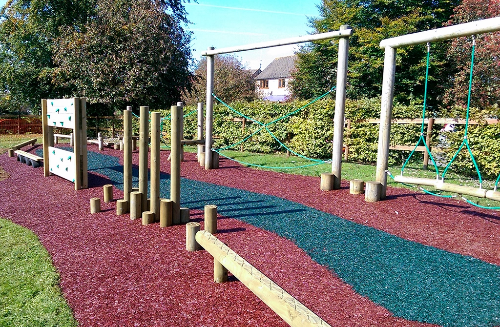 JungleMulch Rubber Mulch Playground with red and dark blue mulch under two trim trails