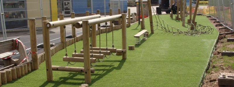 Artificial Grass | Under Trim trail Wooden play equipment installed over artificial grass in school play area
