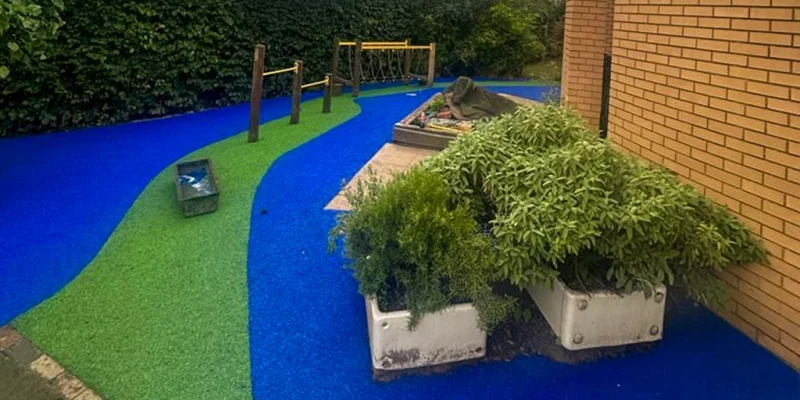Colourful EPDM rubber walkway Vibrant green and blue EPDM rubber walkway under playground equipment