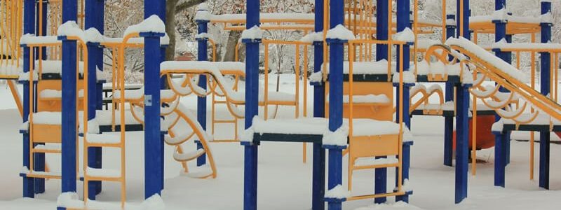 A colourful playground structure covered in snow